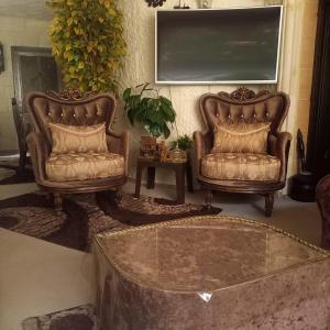 two leather chairs and a table in a living room at شقه مفروشه مع حديقه اربد بجانب مدارس دار العلوم in Irbid
