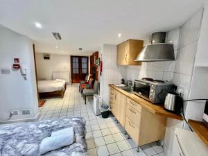 a room with a kitchen and a bedroom with a bed at Stay in Bloomsbury2 in London
