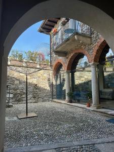 um pátio de pedra com um arco num edifício em Casa Stella a due passi da Orta em Ameno