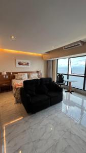 sala de estar con sofá y cama en Flat no Condomínio do Edifício Tropical Executive e residence com Vista para o Rio en Manaus