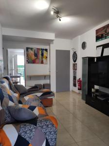 un soggiorno con divani e TV a schermo piatto di CHALET BAJO CON JARDÍN, PATIO, CENADOR Y BARBACOA. a Viveda