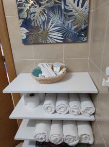 una mensola bianca in bagno con asciugamani e un cesto di CHALET BAJO CON JARDÍN, PATIO, CENADOR Y BARBACOA. a Viveda