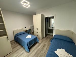 ein kleines Schlafzimmer mit 2 Betten und einem Schreibtisch in der Unterkunft Giagi B&B in Trient