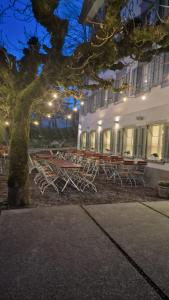 Peterhof Sarnen في سارمن: مجموعة من المقاعد أمام المبنى في الليل