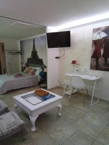 Zimmer mit einem Bett und einem Tisch in einem Zimmer in der Unterkunft Maison Coquelicot in Saint-Georges-du-Bois