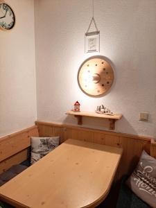 a room with a table and a clock on the wall at Studio "Children of Powdersnow" in Mühlbach am Hochkönig