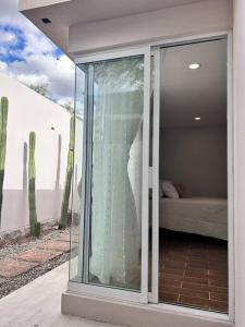 a room with a glass door with a bed in it at casa chabela in Tlacolula de Matamoros