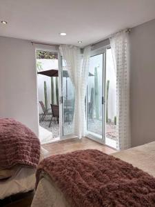 1 dormitorio con 1 cama y puerta corredera de cristal en casa chabela, en Tlacolula de Matamoros