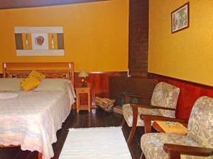 雷森迪德馬烏阿的住宿－Hotel Cantinho de Férias，配有一张床和一把椅子的酒店客房