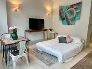 a living room with a couch and a tv at Cute 1-Bedroom Ground Apartment in Stoke Newington in London