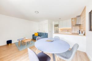 a white living room with a white table and chairs at Cosy appartement Proche Disneyland Paris in Montévrain