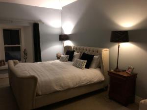 1 dormitorio con 1 cama con sábanas y almohadas blancas en Restored Historic House in Clare, en Ennis
