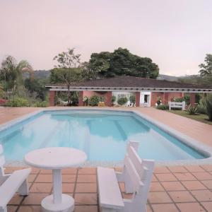 una piscina con mesa y sillas frente a una casa en Finca cerca a Cali - Pura Naturaleza - El Carmen, Colombia, en Papagalleros
