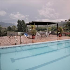 uma piscina com cadeiras e um gazebo em Finca cerca a Cali - Pura Naturaleza - El Carmen, Colombia em Papagalleros