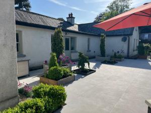 Casa con patio y sombrilla roja en Restored Historic House in Clare, en Ennis