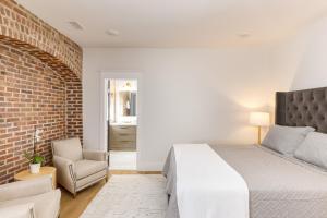 a bedroom with a bed and a brick wall at State St A by AvantStay Heart of French Quarter in Charleston