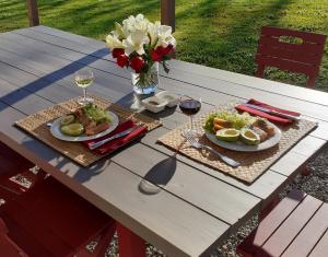 - une table de pique-nique avec deux assiettes de nourriture et des verres de vin dans l'établissement La Chambre des Marronniers, à La Romieu