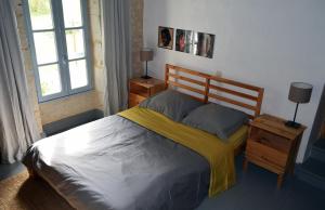 - une chambre avec un lit doté d'une couverture jaune dans l'établissement La Chambre des Marronniers, à La Romieu
