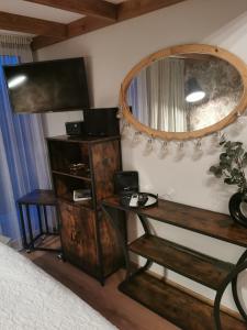 1 dormitorio con espejo, mesa y cama en Austrumi en Kolka
