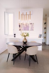 a dining room with a black table and two chairs at Via Dante Luxury Home in Bari