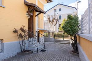 una calle con un edificio amarillo con escaleras y árboles en La Villetta a Cuneo, en Cuneo
