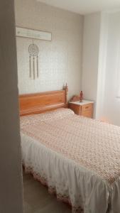 a bedroom with a bed and a clock on the wall at Apartamento playa Muchavista in El Campello