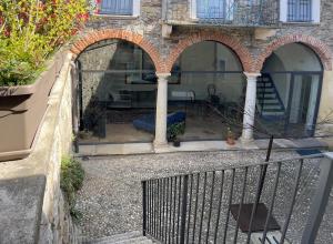 um pátio exterior com três arcos num edifício em Casa Stella a due passi da Orta em Ameno