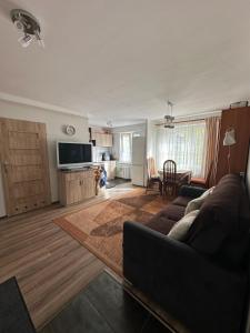 ein Wohnzimmer mit einem Sofa und einem Tisch in der Unterkunft Przytulne mieszkanie blisko kanalu in Giżycko