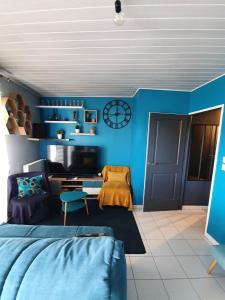 ein blaues Zimmer mit einem Bett und einer Couch in der Unterkunft T2 Cubano Montpellier Parking Proche Plages in Montpellier