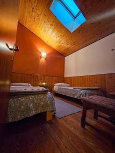 a room with three beds and a skylight at Rifugio Guglielmo e Giovanni Pelizzo in Montemaggiore