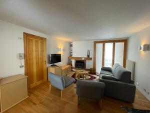 a living room with a couch and chairs and a television at Chalet Le Case in Madonna di Campiglio