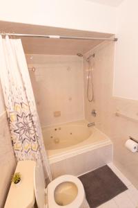 a bathroom with a toilet and a bath tub at Elegant & Spacious 3-bed Gem mins to NYC in Jersey City