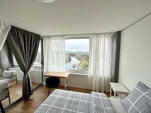 3.5Room@MydiHei Apartments في نيوهاسن ام رينفا: غرفة نوم بسرير ونافذة كبيرة