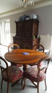 uma mesa de madeira com 2 cadeiras e um armário de madeira em Appartement pour un couple, jacuzzi en été, jardin em Genebra