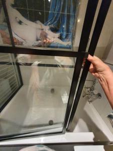 a person holding up a window in a bath tub at Appartement pour un couple, jacuzzi en été, jardin in Geneva