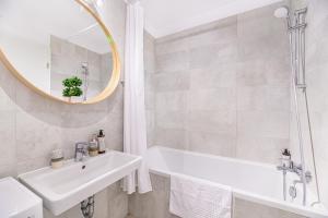 a bathroom with a sink and a tub and a mirror at JAD Luxury Apartments Kasper in Braşov +69 photos