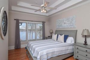 een slaapkamer met een bed en een plafondventilator bij Southern Comfort Cabin in Lake Murray Shores