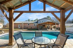 a patio with a table and chairs next to a swimming pool at Spacious Oasis With Pool - 5BR in Columbia