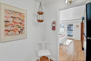 Un comedor con una silla blanca y un cuadro en la pared. en The Rainbow Room - Studio Apt, en Columbia