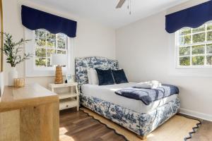 a bedroom with a bed and two windows at Blue Haven of Rosewood in Columbia