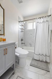 a white bathroom with a toilet and a shower at Blue Haven of Rosewood in Columbia