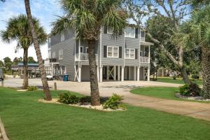a large house with palm trees in front of it at Water front Getaway w. Boat Docks / Fishing in Orange Beach