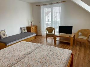 - une chambre avec 2 lits, une télévision et des chaises dans l'établissement Apartmán Tereza, à Poděbrady
