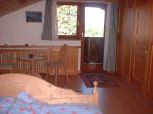 a bedroom with a bed and a table and a window at Ferienhaus Knittel Verm nur Samstag auf Samstag in Murnau am Staffelsee