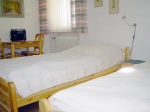 two twin beds in a room with a table at Ferienhaus Knittel Verm nur Samstag auf Samstag in Murnau am Staffelsee