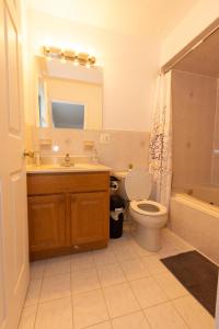 a bathroom with a sink and a toilet and a mirror at Elegant & Spacious 3-bed Gem mins to NYC in Jersey City
