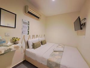 um pequeno quarto com uma cama e uma televisão em SCC Gateway Chinatown Hotel em Kuala Lumpur