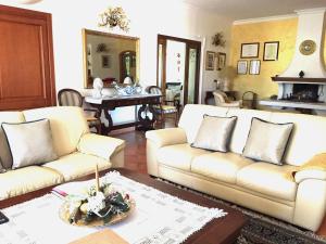 uma sala de estar com dois sofás brancos e uma mesa em Villa Aurora em Le Castella