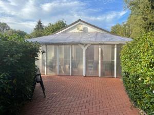 a large greenhouse with glass doors and a bench at Zur Fellnase in Horka