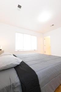 a bedroom with a large bed in a white room at Elegant & Spacious 3-bed Gem mins to NYC in Jersey City